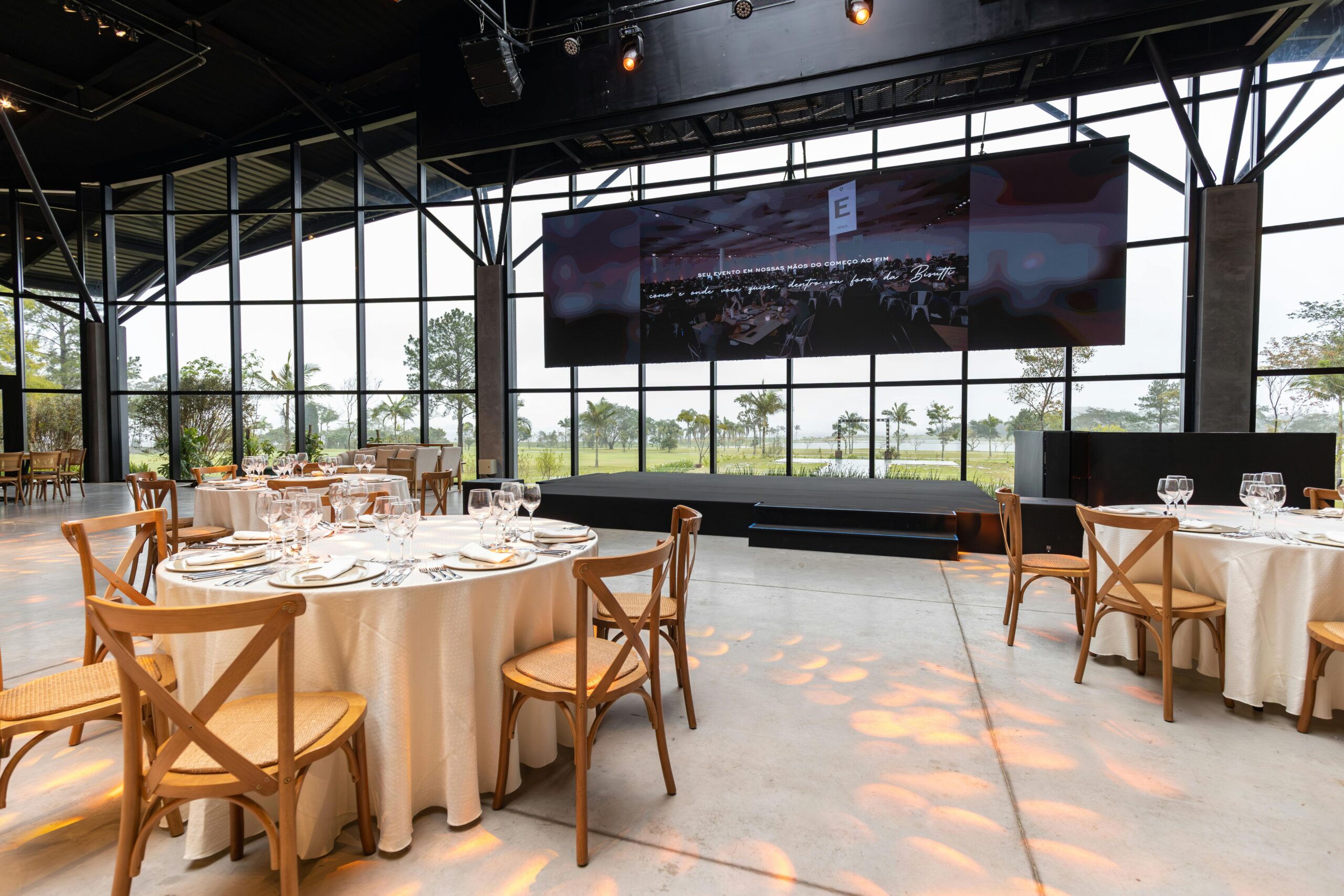 Elegant banquet hall featuring set tables, large screen, and modern interior design.