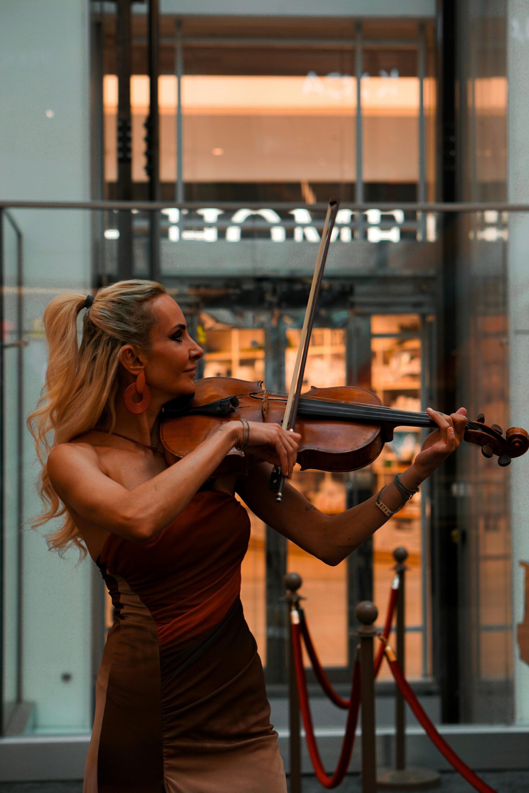 Young woman playing violin outdoors in Ankara, creating a vibrant city atmosphere.